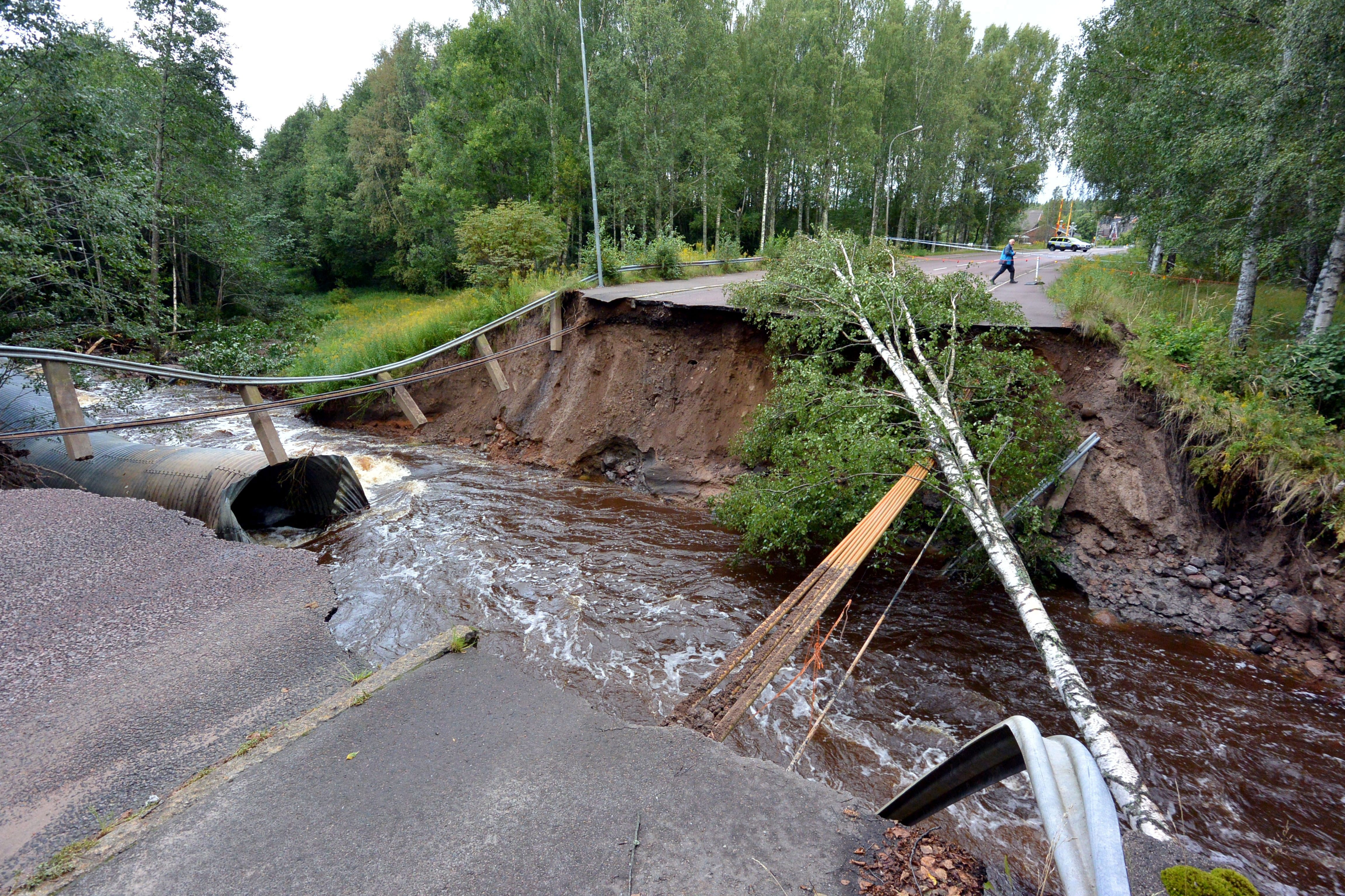 A rain-swollen river washed away the road and felled trees in Kristinehamn, western Sweden, on August 22, 2014. (Johan Nilsson/AFP/Getty Images)