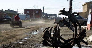 An ATV drives past caribou horns on one of the dirt roads in the Arctic town of Barrow, Alasksa. (Al Grillo / AP)