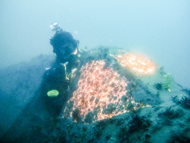 Bjørn Ballo sits in the cockpit of the downed P-40 plane, a vestige of the Second World War under Jarfjord in Kirkenes. (Jimmy Thomson/Barents Observer)