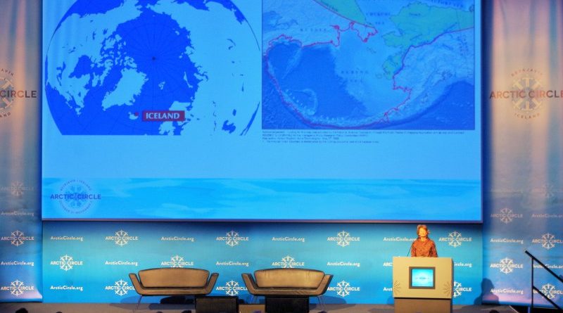 U.S. Senator Lisa Murkowski addresses Arctic Circle 2014 in Reykjavik, Iceland, with a map behind her of two polar opposite cities in the Arctic. (Mia Bennett)