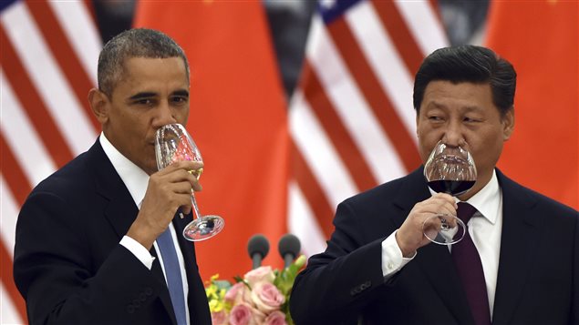 U.S. President Barack Obama, left, and Chinese President Xi Jinping drink a toast on Nov. 12, 2014. The two leaders pledged to take ambitious action to limit greenhouse gases ahead of climate change negotiations next year. (Greg Baker/AP)