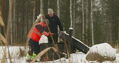 Saloy CEO Tapio Salminen (right) demonstrates the use of a phosphorus recovery device. (Yle)