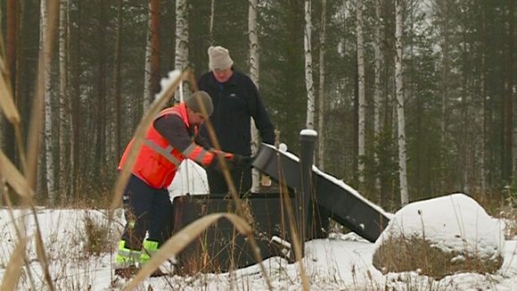 Saloy CEO Tapio Salminen (right) demonstrates the use of a phosphorus recovery device. (Yle)