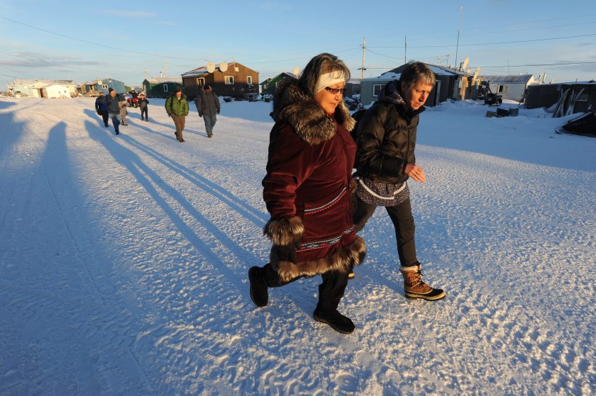 Millie Hawley and Interior Secretary Sally Jewell walk down the main street in the Inupiat village of Kivalina, Alaska  on Monday, Feb. 16, 2015.  The village is threatened by coastal erosion of the long barrier island between the Chukchi Sea and a lagoon at the mouth of the Kivalina River. (Bill Roth / Alaska Dispatch News)