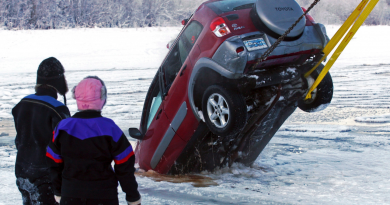 A dive crew watches the recovery of a vehicle from the icy water near the Pike's Landing Chena River Ice Bridge entrance in Fairbanks, Alaska on Dec. 19, 2014. (Eric Engman /The Fairbanks Daily News-Miner/AP)