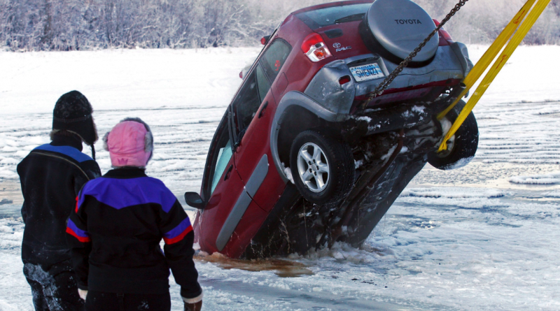 A dive crew watches the recovery of a vehicle from the icy water near the Pike's Landing Chena River Ice Bridge entrance in Fairbanks, Alaska on Dec. 19, 2014. (Eric Engman /The Fairbanks Daily News-Miner/AP)