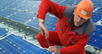 Worker installs solar panels. File photo. (Yle)