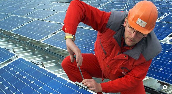 Worker installs solar panels. File photo. (Yle)