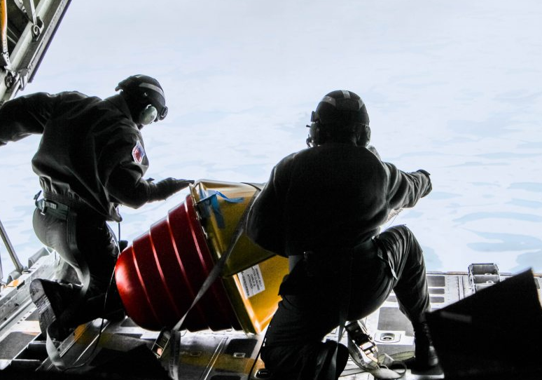 Two U.S. Coast Guard drop masters on an Arctic Domain Awareness flight push a weather buoy into the ocean north of Deadhorse on Tuesday, July 14, 2015. (Kamala Kelkar/Alaska Dispatch News)