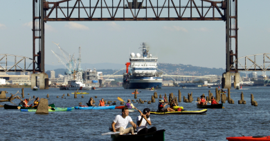 oaters gather as the Royal Dutch Shell PLC icebreaker Fennica heads under a railroad bridge and up the Willamette River in Portland, Ore., Thursday, July 30, 2015. The Fennica left dry dock and made its way down the Willamette River toward the Pacific Ocean soon after authorities forced the demonstrators from the river and the St. Johns Bridge. (Don Ryan/AP)