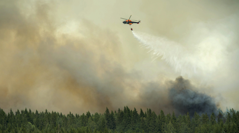 A helicopter drops a load of water on the wildfire front just outside the evacuated village of Gammelby near Sala, Central Sweden, on August 4, 2014. The fire was classified as the worst forest fire in Sweden's modern history. (Fredrick Sandberg/AFP/Getty Images)