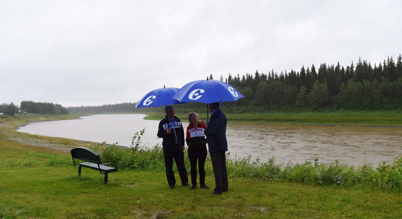 Conservative Leader Stephen Harper, right, and his wife Laureen talk with Conservative candidate for the Northwest Territories Floyd Roland as they visit the banks of the Hay River in Hay River, Northwest Territories, on Friday, August 14, 2015. (Sean Kilpatrick/The Canadian Press)