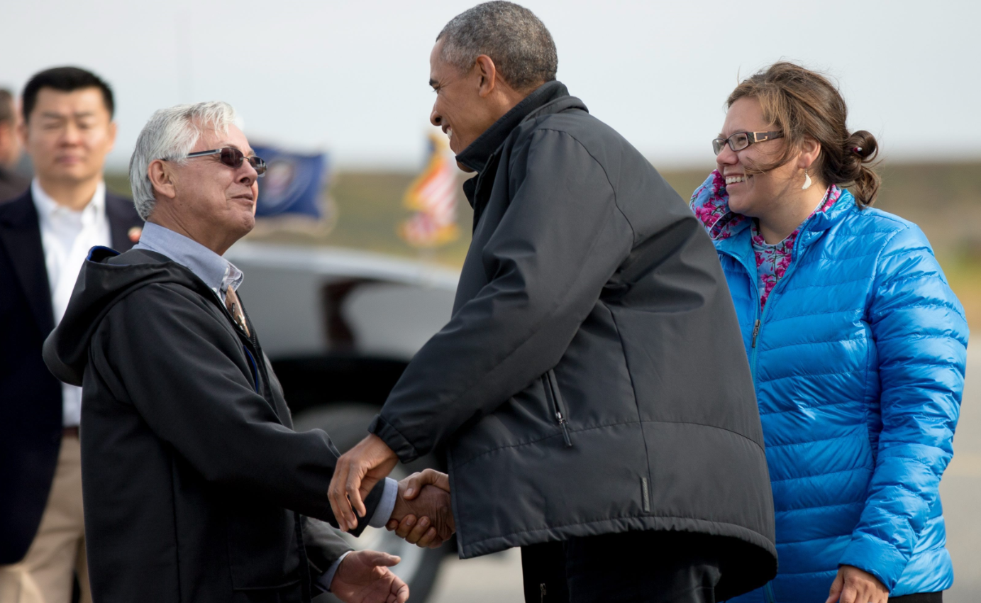 U.S. President Barack Obama is greeted in Alaska by Kotzebue mayor Maija Lukin, right, and Northwest Arctic Borough mayor Reggie Joule, left, as he arrives at Ralph Wien Memorial Airport, Wednesday, Sept. 2, 2015. This week, indigenous leaders travel to Washington D.C. for a tribal conference. (Andrew Harnik/ AP)