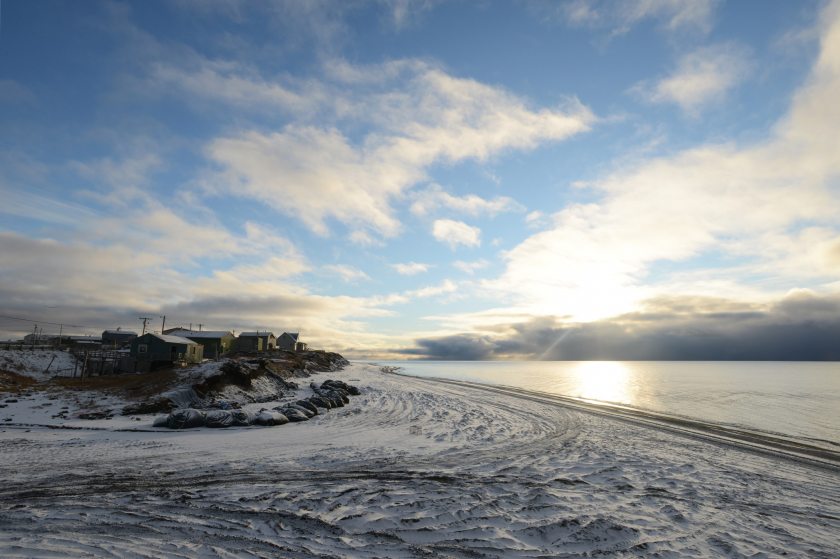 Following a snowstorm, the sun makes an evening appearance in the bluffs that include the Ukkuqsi archaeological site in Barrow, Alaska. Sand bags help protect the site, which once again yielded human remains following a late-August storm. (Erik Hill/Alaska Dispatch News)