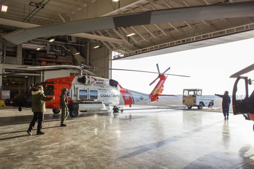 The Coast Guard crew at a forward operating location in Deadhorse direct a Jayhawk helicopter out of its hander and onto the tarmac on October 11, 2015. The departure of the Coast Guard was delayed by a day due to a valve malfunction. (Asaf Shalev/Alaska Dispatch News)