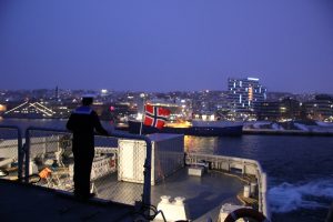 A sailor looks out at Tromso, Norway from the Norwegian icebreaker KV Svalbard. (Eilis Quinn/Eye on the Arctic)