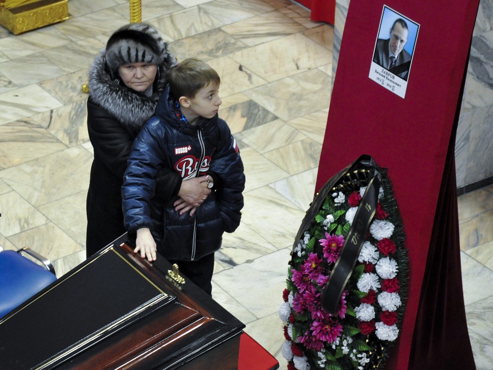 Relatives stand next to the coffin of Vitaly Lavrov, one of the dead miners, during a funeral in Vorkuta, a town north of the Arctic Circle in Russia Monday, Feb. 29, 2016. (Semen Volodin/AP Photo)