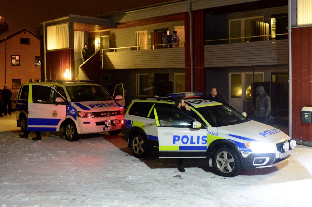 Swedish police stand by police cars outside a house used as a temporary shelter for asylum seekers in Boliden in northeastern Sweden Thursday, Nov. 19, 2015, after police arrested a man believed to be suspected of planning terror crimes in Sweden. (Robert Granstrom/TT via AP)