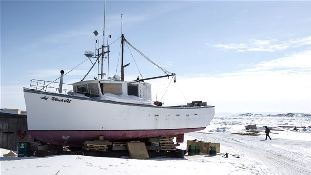 A man walks along the frozen shoreline Saturday, April 25, 2015 in Iqaluit, Nunavut. (Paul Chiasson/The Canadian Press)