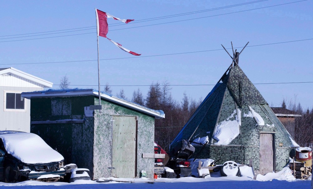 A tattered Canadian flag flies over a building in Attawapiskat, Ont., on November 29, 2011. A remote northern Ontario First Nation has declared a state of emergency after numerous suicide attempts this week. Adrian Wyld/THE CANADIAN PRESS