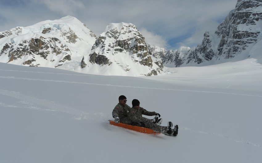 Sgt. Jose Meza-Rangel and Sgt. William Dickey join other soldiers taking sled rides down the slope before leaving the Kahiltna Glacier on Sunday. Bob Hallinen / ADN