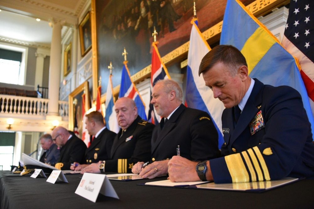 U.S. Coast Guard Commandant Adm. Paul Zukunft (right) and the heads of seven other Arctic nations' coast guards sign a joint statement in Faneuil Hall in Boston, June 10, 2016. (Petty Officer 2nd Class Patrick Kelley/U.S. Coast Guard)