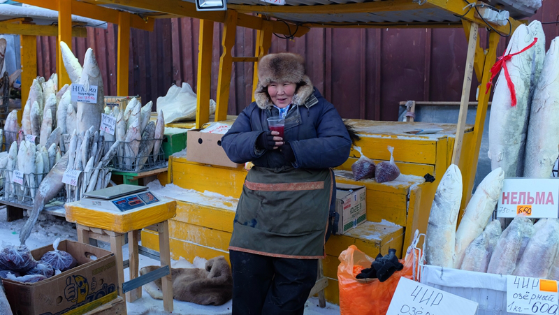 A fish vendor drinking berry juice at the local market in Yakutsk. Life is pretty good!