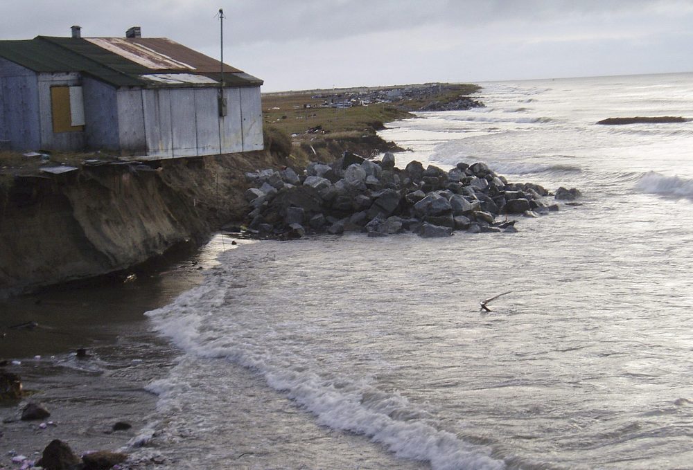 This 2005 photo provided by Tony Weyiouanna Sr. shows a building over a beach in Shishmaref, Alaska. Weyiouanna remembers a time when people played baseball on the beach of his village on Alaska's western coast. Now, there's barely enough room for hopscotch on Shishmaref's eroding waterfront. Erosion is an escalating problem blamed on climate change. (Tony Weyiouanna Sr./AP Photo)