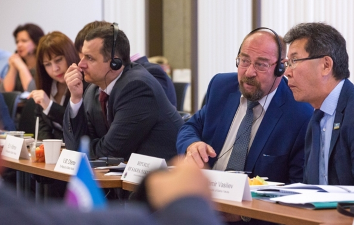 Vladimir Chlenov, left, and Vladimir Vasiliev, representing the Russian regions of Yamal-Nenets and Sakha (Yakutia), listen to a presentation in English at the Atwood building in Anchorage during the second day of the Northern Forum on Tuesday. (Loren Holmes / Alaska Dispatch News)