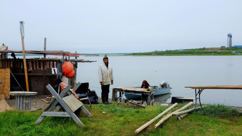 A man and his fishing hut, with the Cold-War era DEW Line visible in the background. (Mia Bennett)