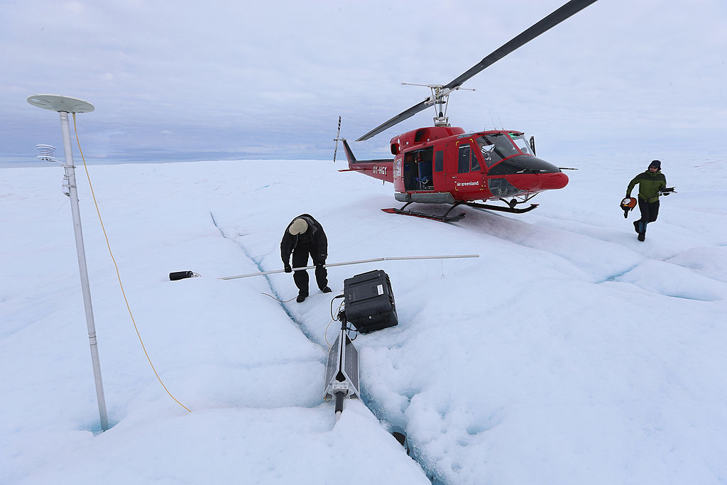 GLACIAL ICE SHEET, GREENLAND - JULY 17: David Shean a Ph.D. student at the University of Washington (R) and Scientist Ian Joughin of the University of Washington place a GPS system into the ice on July 17, 2013 on the Glacial Ice Sheet, Greenland. Joughin and his fellow scientist, Sarah Das, from the Woods Hole Oceanographic Institution use the Global Positioning System sensors to closely monitor the evolution of surface lakes and the motion of the surrounding ice sheet. As the sea levels around the globe rise, researchers affiliated with the National Science Foundation and other organizations are studying the phenomena of the melting glaciers and its long-term ramifications. In recent years, sea level rise in places such as Miami Beach has led to increased street flooding and prompted leaders such as New York City Mayor Michael Bloomberg to propose a $19.5 billion plan to boost the citys capacity to withstand future extreme weather events by, among other things, devising mechanisms to withstand flooding. (Photo by Joe Raedle/Getty Images)