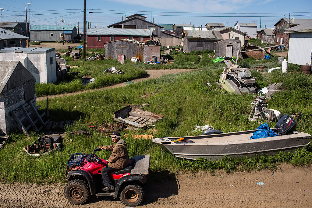 A man drives down the street on an ATV on July 9, 2015 in Shishmaref, Alaska. (Andrew Burton/Getty Images)