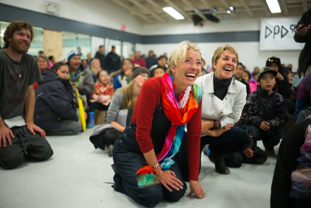 Vancouver Renewable Energy Coop Solar Installer, Duncan Martin (L), actor, writer and activist, Emma Thompson and Executive Director of Greenpeace Canada, Joanna Kerr watch entertainment during the solar celebration at the Clyde River community centre. 