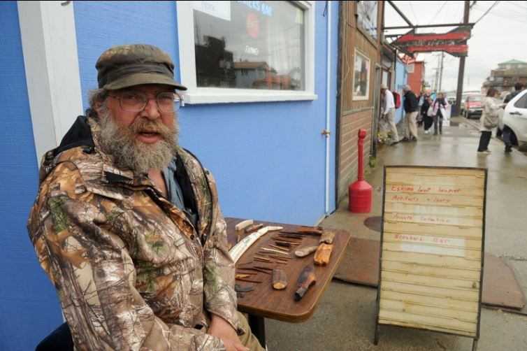 Roger Thompson offers ivory for sale to passengers of the Crystal Serenity cruise ship in Nome, AK in front of the Breakers Bar on Sunday, August 21, 2016. The cruise ship is on its way across the Northwest Passage, the largest passenger ship to attempt the crossing. (Bob Hallinen / Alaska Dispatch News)