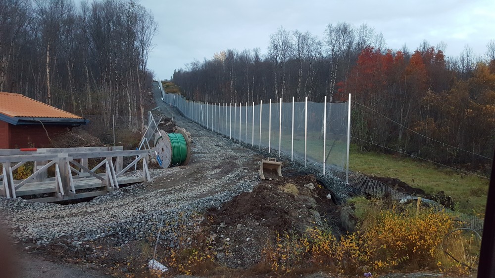 No work on the fence until more measurments are done. A few centimeters too far to the east could force the entrepreneur to tear down up to 50 meters of the disputed security fence. Photo from late Saturday evening. (Thomas Nilsen/The Independent Barents Observer)