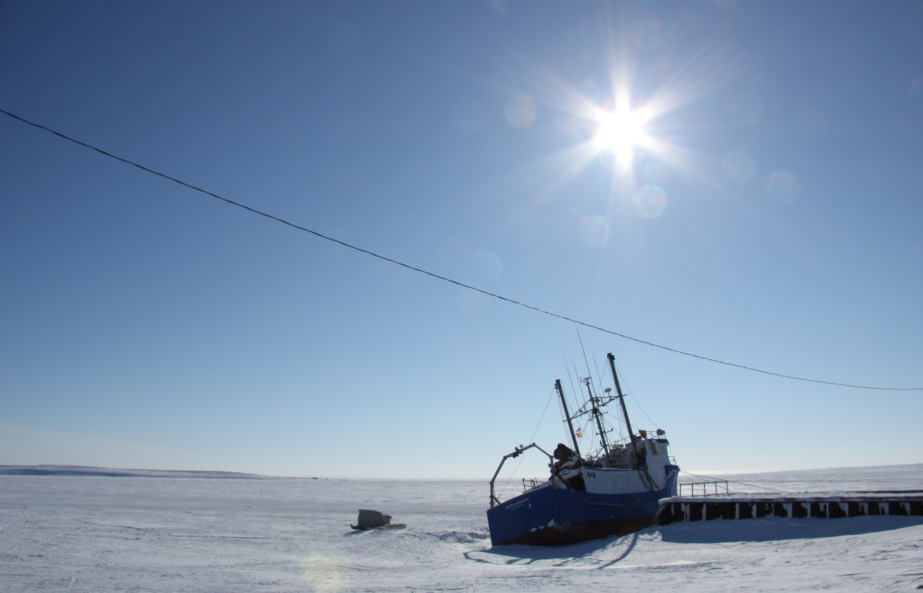 A komatik (an Inuit sled) beside a boat outside of Cambridge Bay, Nunavut. (Eilís Quinn/Eye on the Arctic)