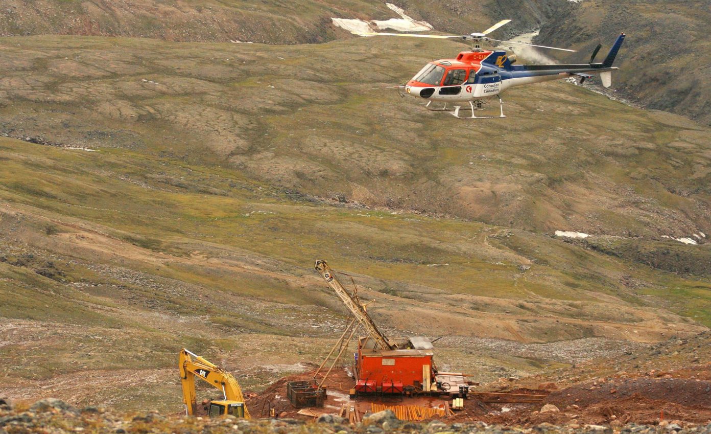 A helicopter passes over excavation equipment at the Mary River exploration camp in 2006. (Vinne Karetak/The Canadian Press)