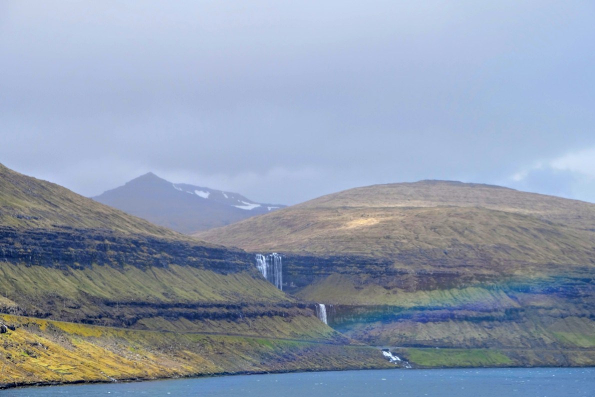 A rainbow arcing in front of the wall.