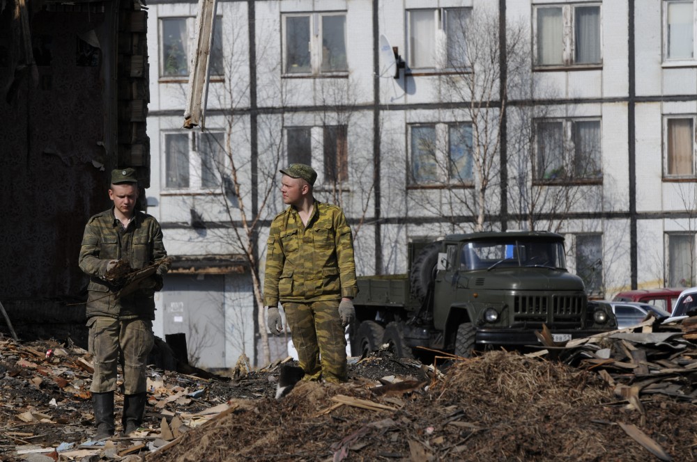 Workers tear down some of the old houses in the center of Korzunovo. (Thomas Nilsen/The Independent Barents Observer)