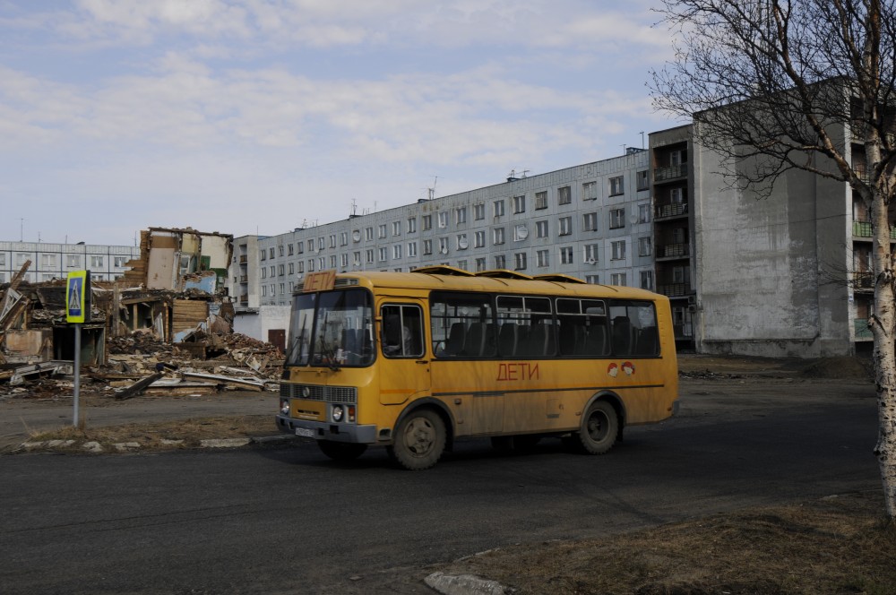 School bus in front of on of the few apartment blocks where people still are living. (Thomas Nilsen/The Independent Barents Observer)