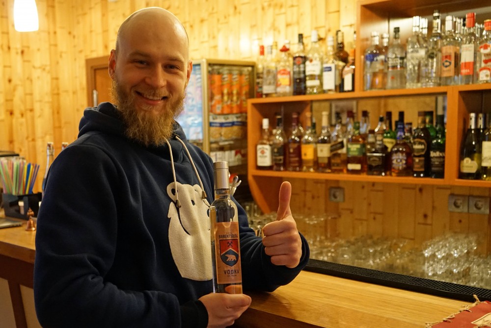 Ivan Velichenko shows a bottle of the town’s own vodka named Barentsburg. (Thomas Nilsen/The Independent Barents Observer)