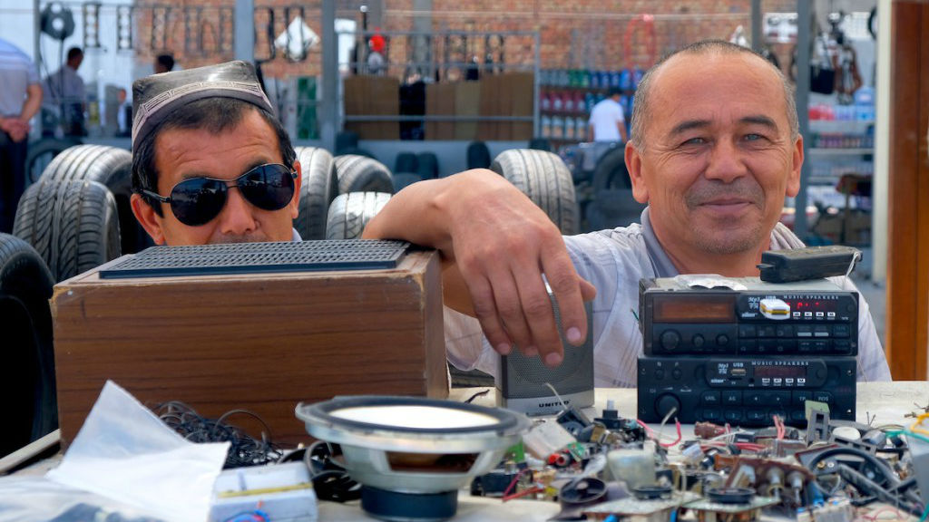 A used car parts salesman with blue eyes across the border at a market in Uzbekistan. (Mia Bennett/Cryopolitics)