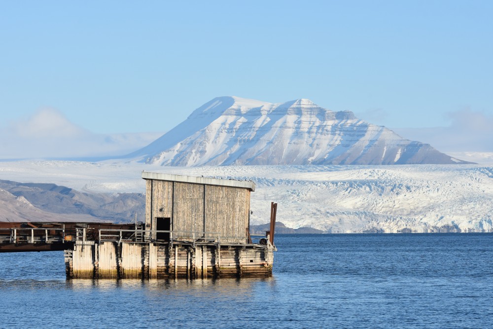 Part of the port facility in Pyramiden. The Nordenskiöld glacier across the fjord. (Thomas Nilsen/The Independent Barents Observer)