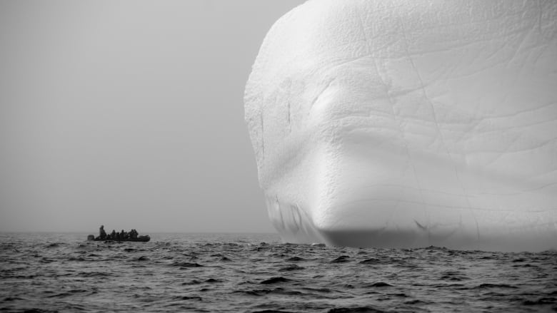 A boat approaches a massive iceberg in Lancaster Sound. Some pleasure craft will be prohibited from sailing in Arctic waters until at least the end of October.