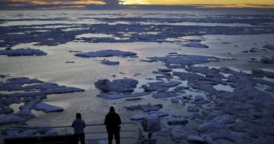 In this July 21, 2017 file photo, researchers look out from the Finnish icebreaker MSV Nordica as the sun sets over sea ice in the Victoria Strait along the Northwest Passage in Canada's Arctic Archipelago.