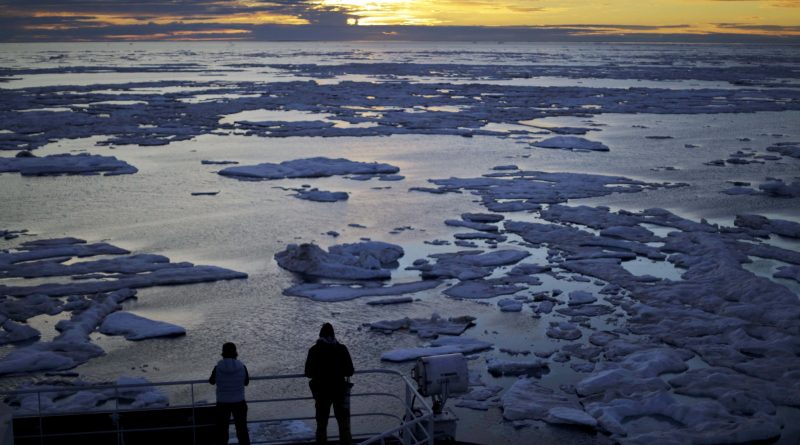 In this July 21, 2017 file photo, researchers look out from the Finnish icebreaker MSV Nordica as the sun sets over sea ice in the Victoria Strait along the Northwest Passage in Canada's Arctic Archipelago.
