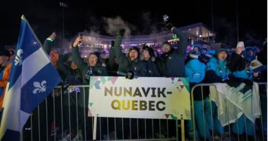 People gathered behind a sign reading "Nunavik Québec" and the Quebec flag.