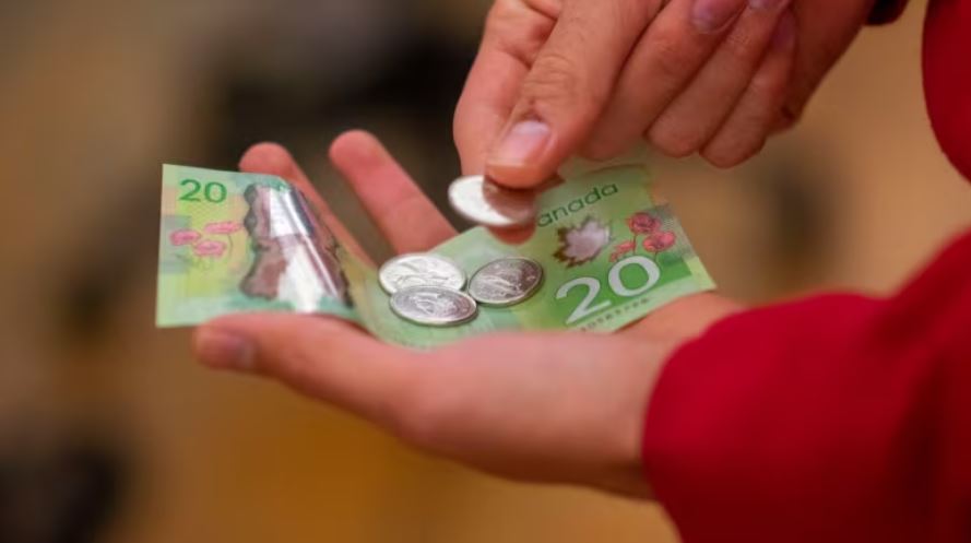 Someone is holding money, including a 20 $.
