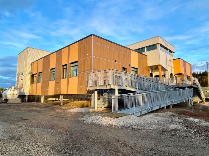 A building with a large walk-up ramp is seen from the outside.