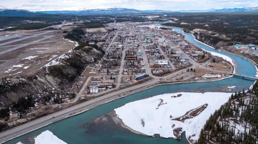 An aerial view of buildings by a riverAn aerial view of downtown Whitehorse.